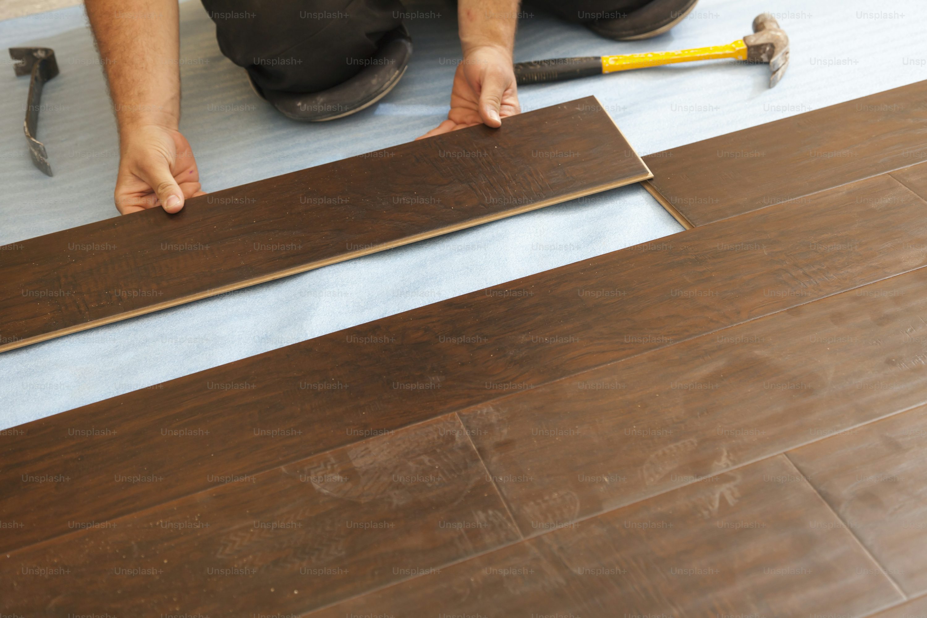 Man Installing New Laminate Wood Flooring Abstract