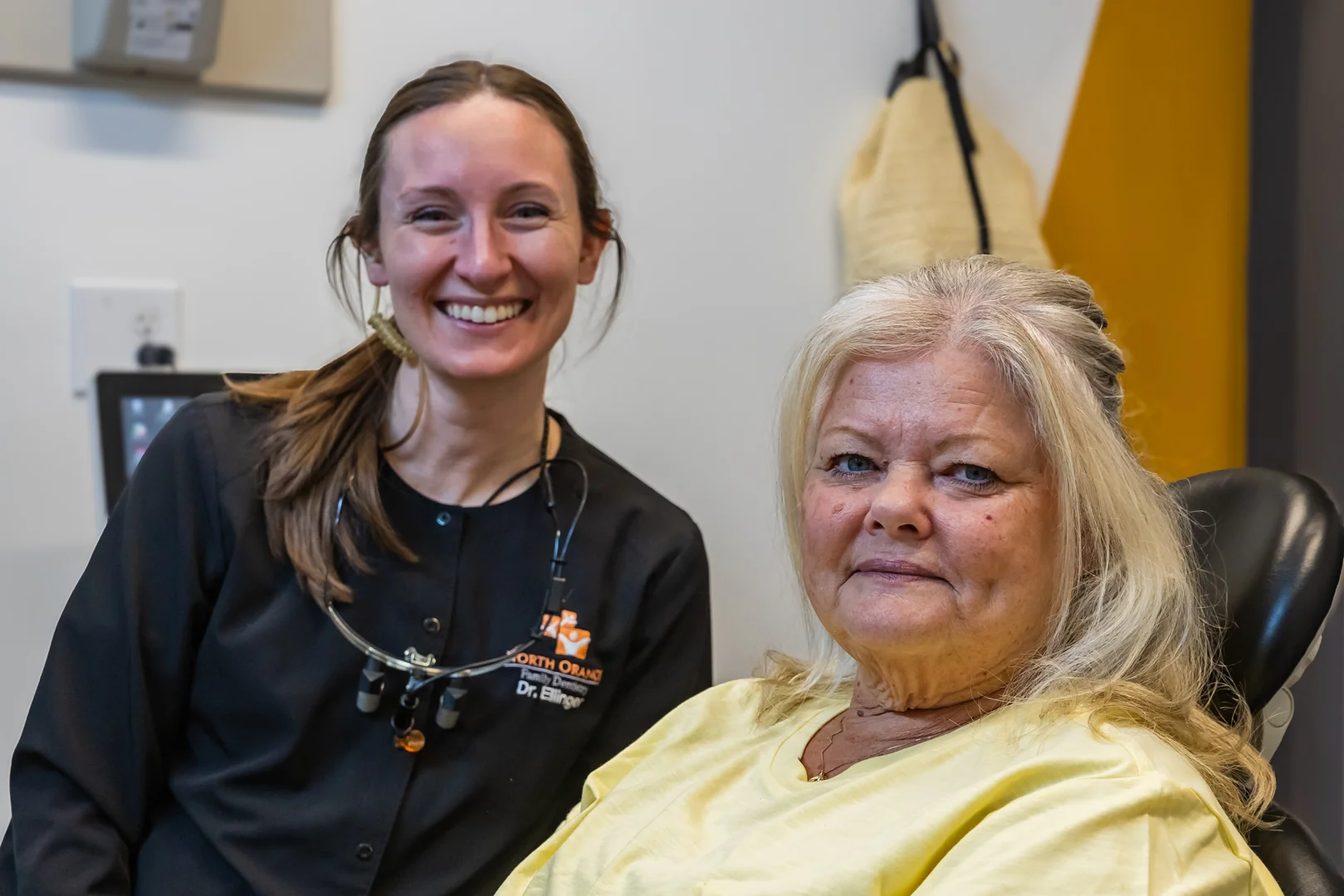 dentist gently explaining a dental procedure to a smiling patient