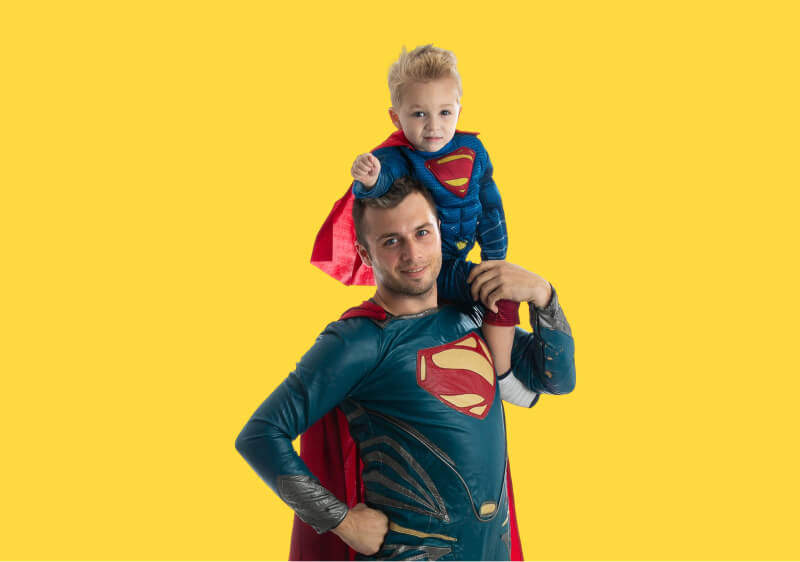 Superman posing for a photo with a Superboy on his shoulder