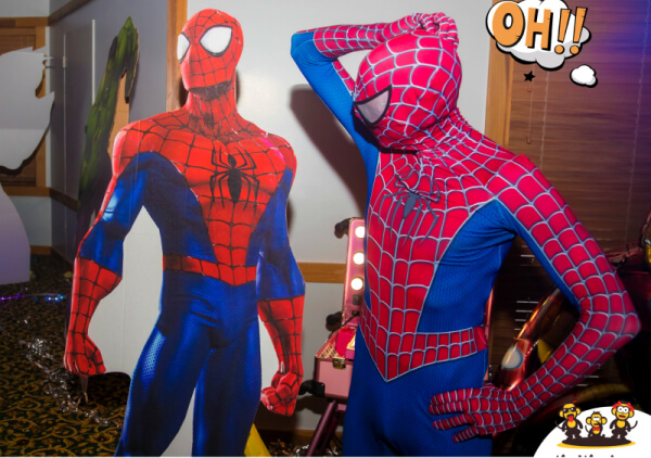 Spiderman checking out a photo cardboard of him at a birthday party