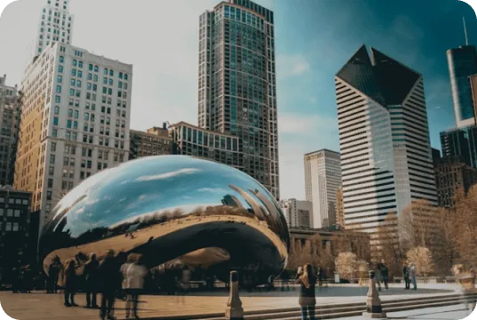 Cloud Gate sculpture, also known as The Bean, reflecting surrounding buildings and people in Millennium Park, Chicago.