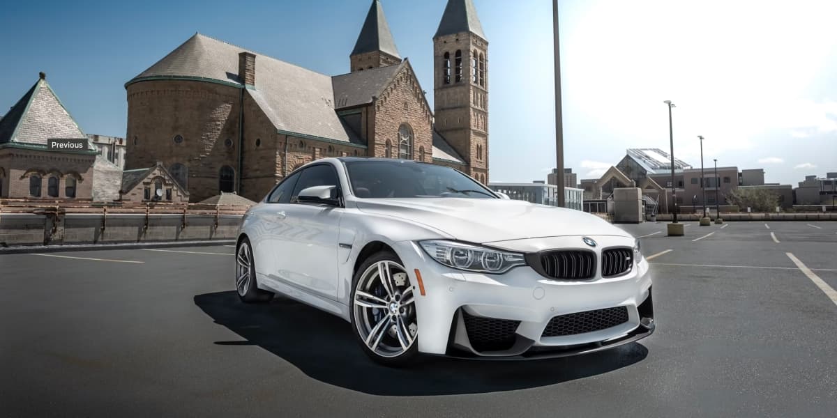 White sedan parked near a historic stone church in an Ohio city