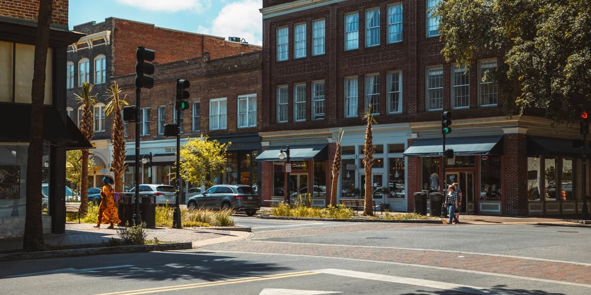 Historic downtown street corner in Georgia lined with brick storefronts and palm trees