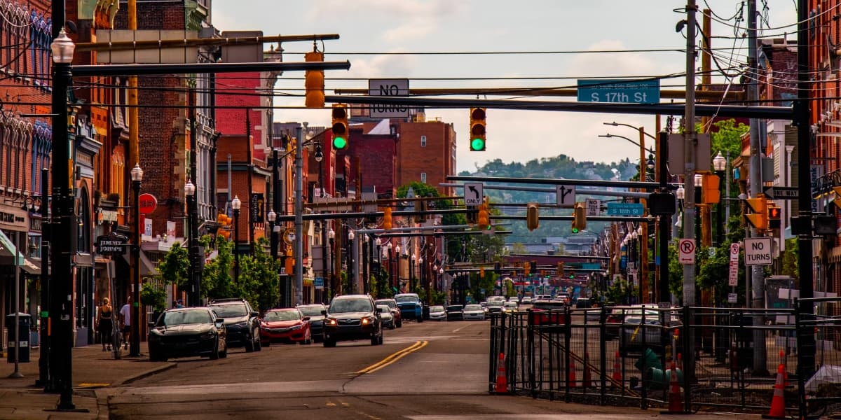 Historic rowhouse-lined city street with traffic signals in Pennsylvania