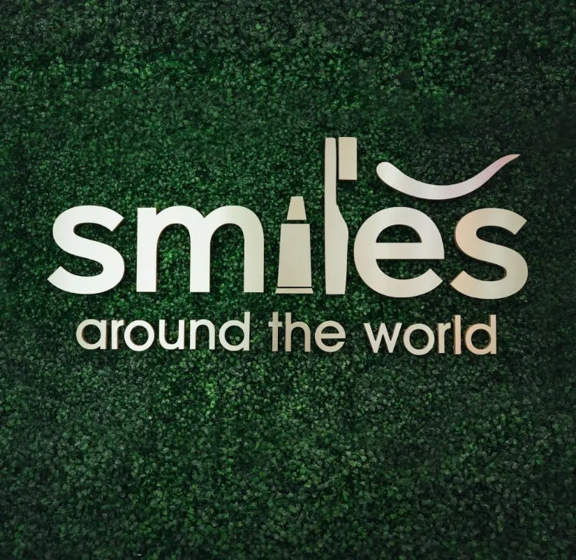 Photo of a wall sign reading, "Smiles around the world"