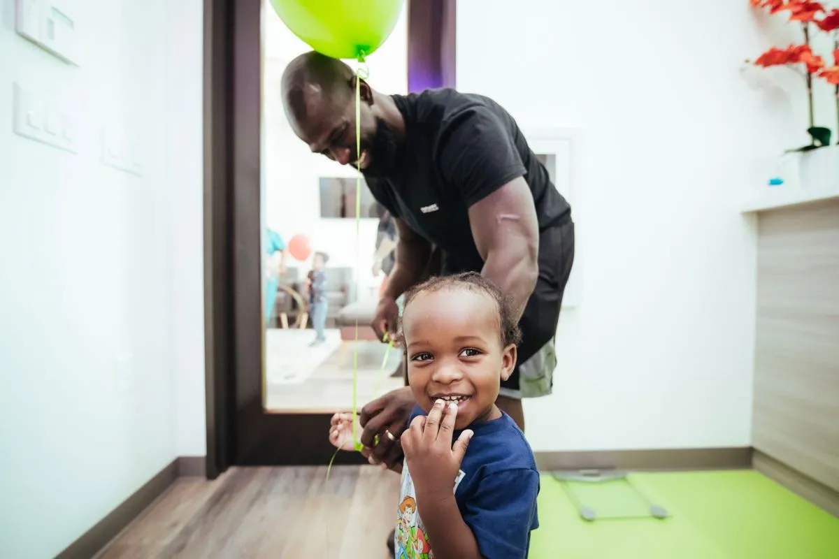 Photo of a dad and his son who is holding a balloon