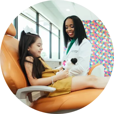 Photo of Dr. Marshall and a young patient sitting in an exam chair