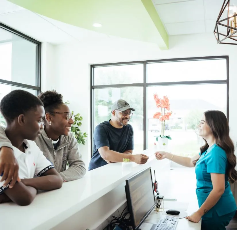 Photo of patients talking to the receptionist at our front desk