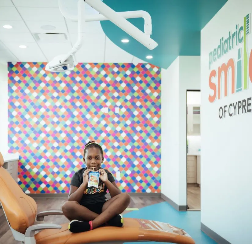 Photo of a pediatric dental patient sitting on an exam chair
