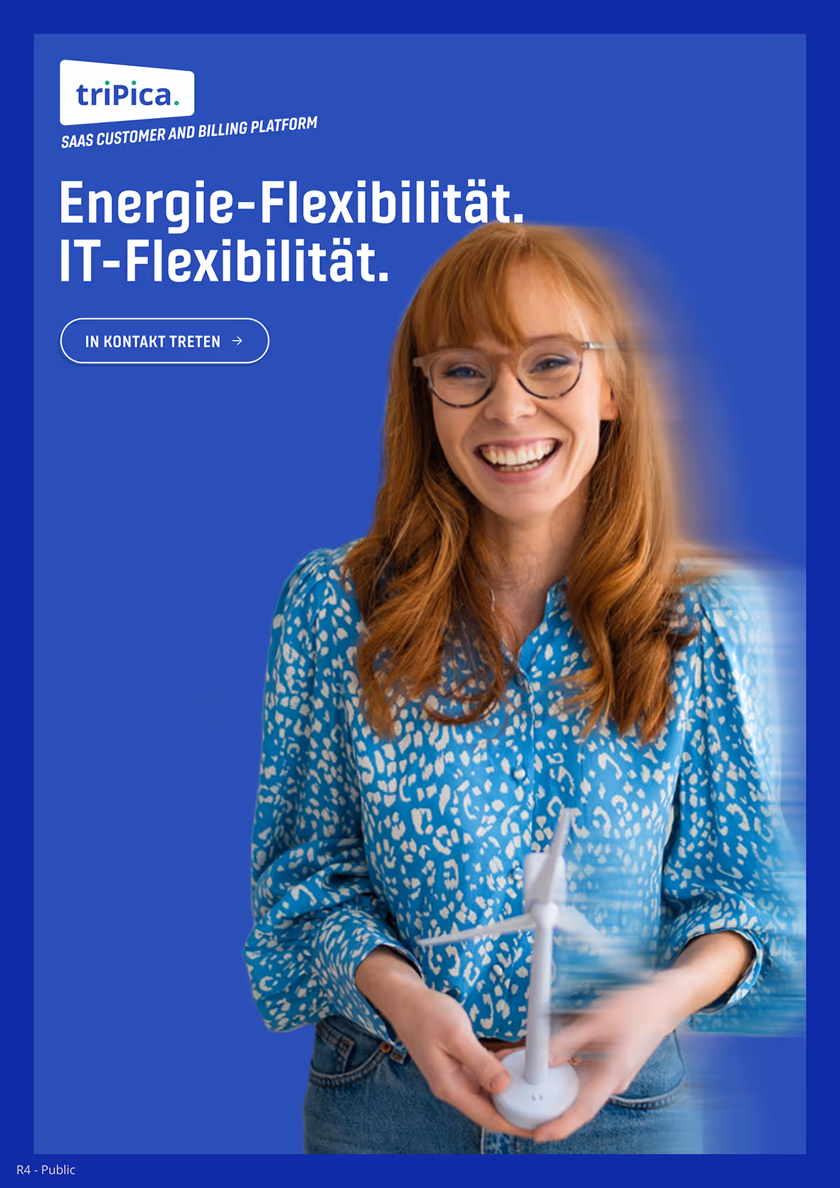 Smiling woman with glasses holding a spinning white wind turbine model against a blue background with text about energy and IT flexibility.