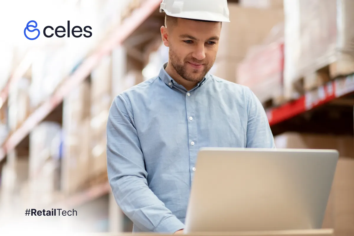 Hombre con casco blanco en almacén: trabaja en laptop sobre cajas, impulsando eficiencia retail tech con Celestes. #RetailTech