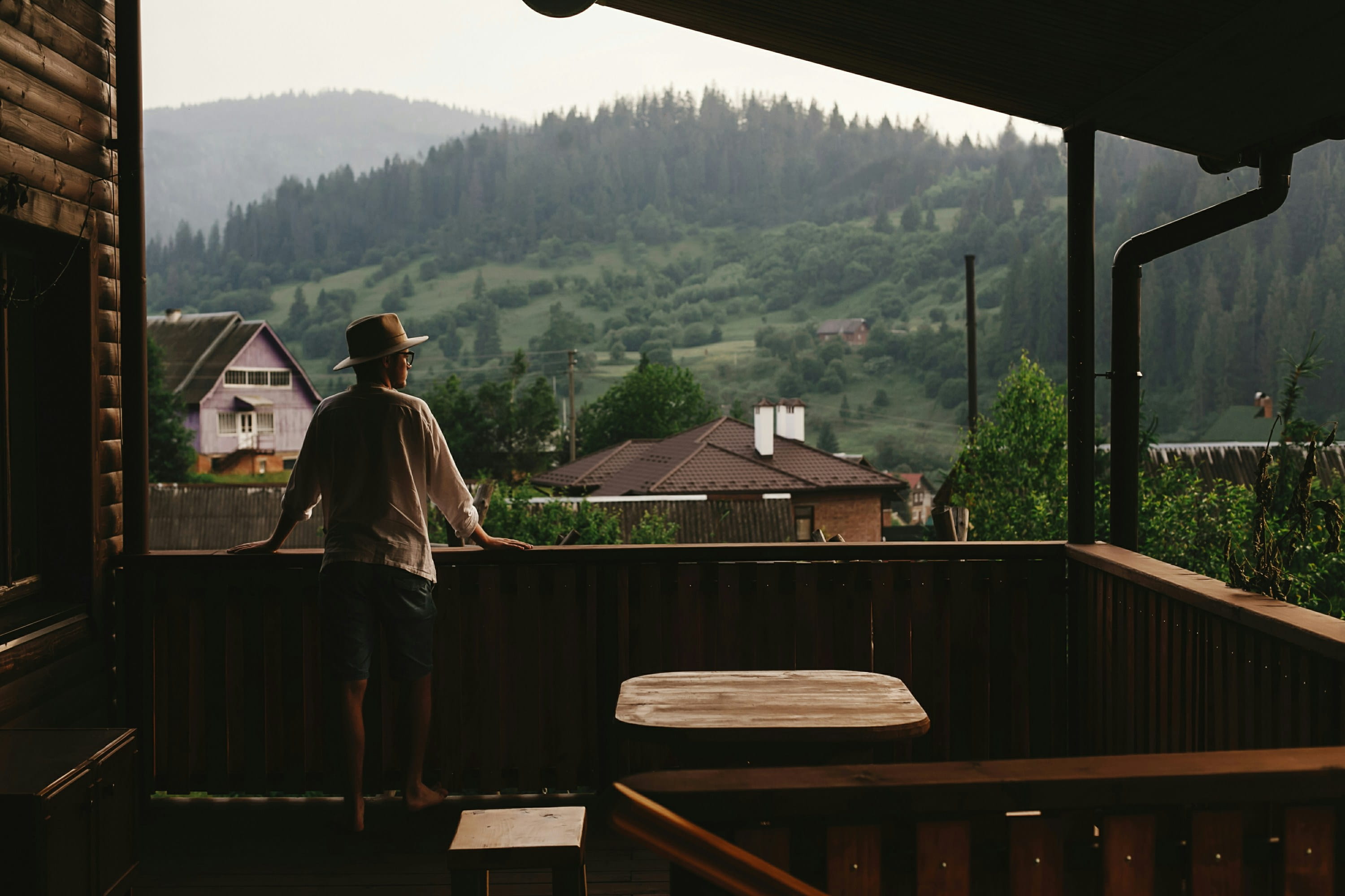 Guest on a wooden balcony looking over the hills
