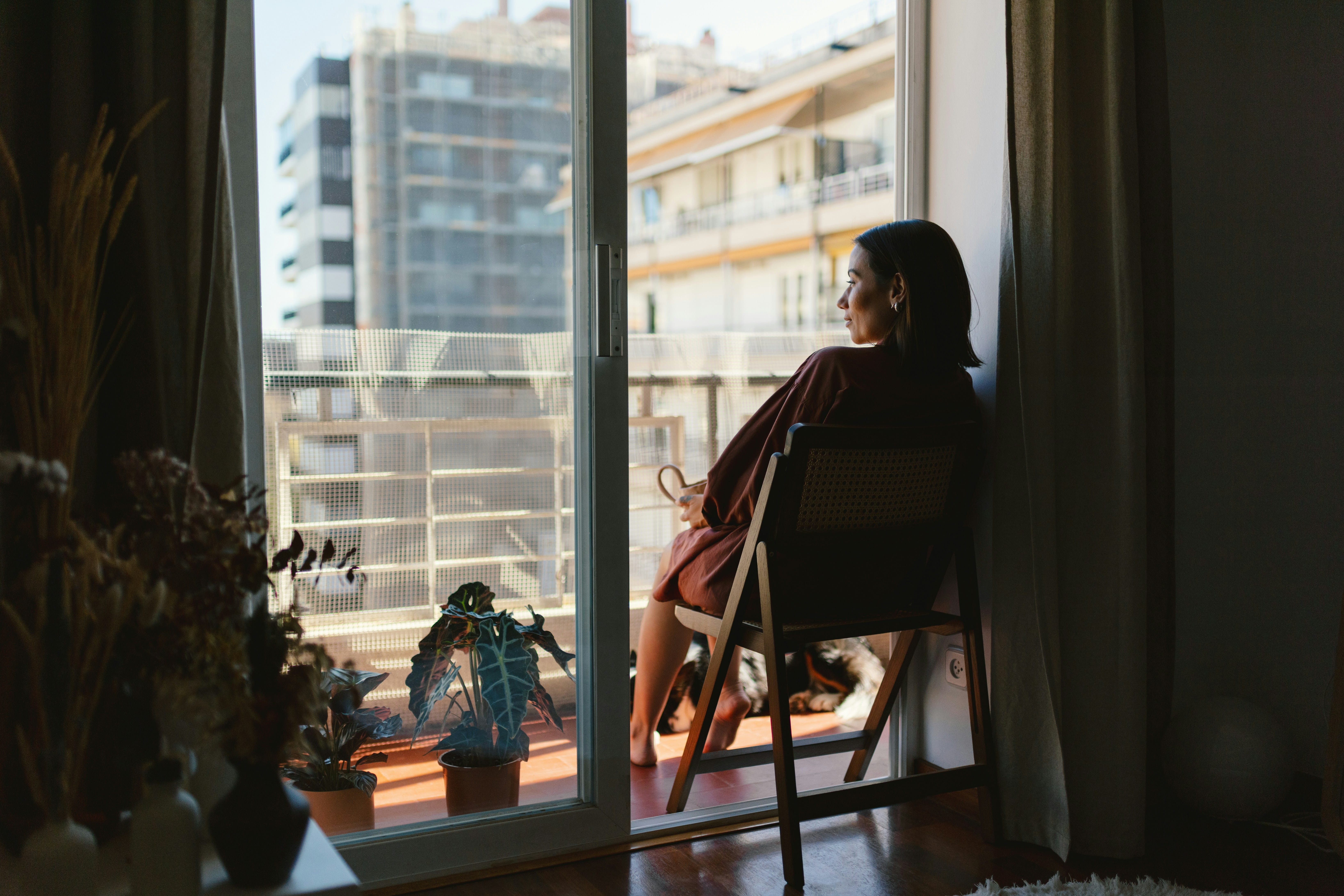 Guest relaxing by a sunny window in a rental apartment