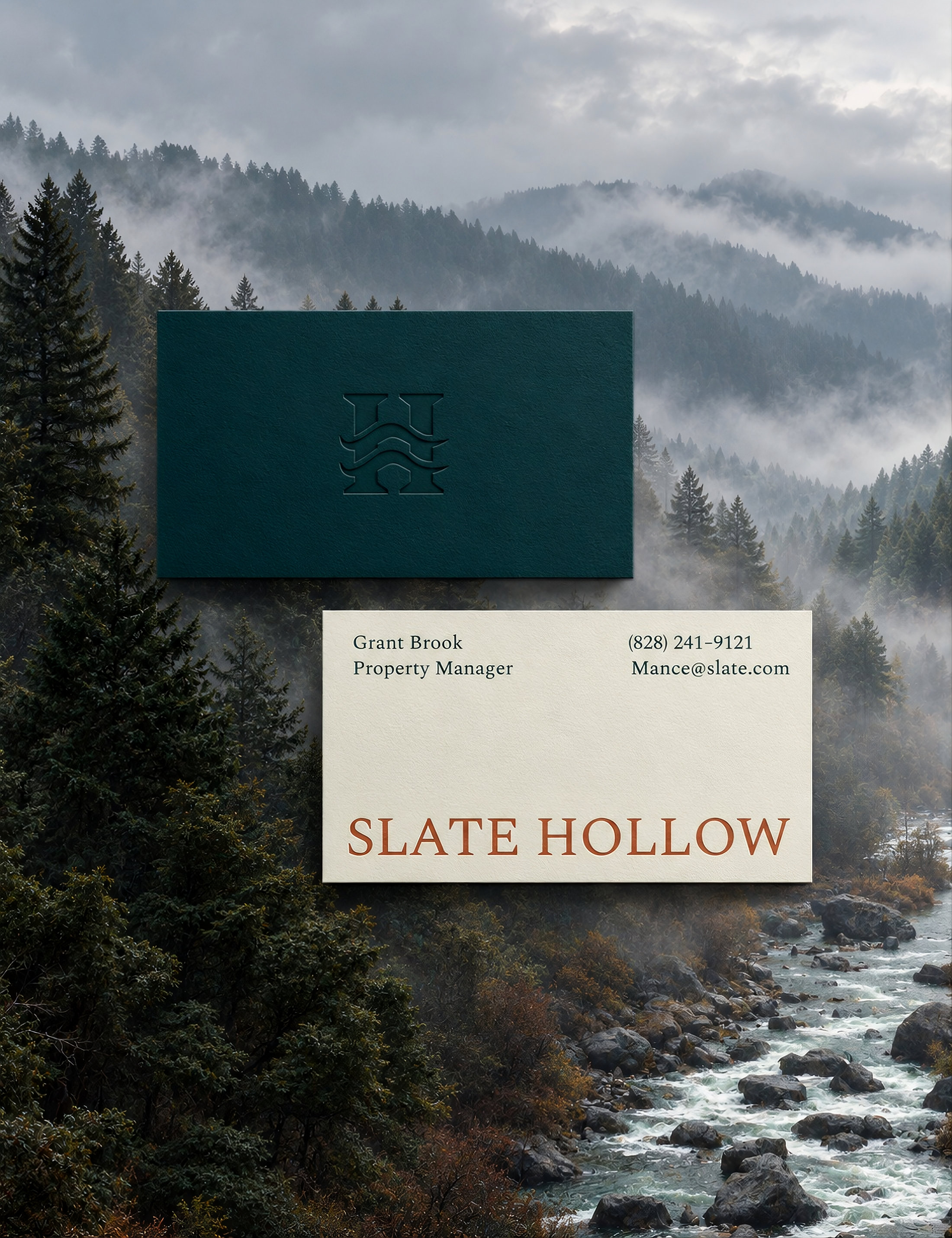 Slate Hollow business cards, one deep green with an embossed monogram and one bone with the wordmark, over a misty Blue Ridge forest and creek