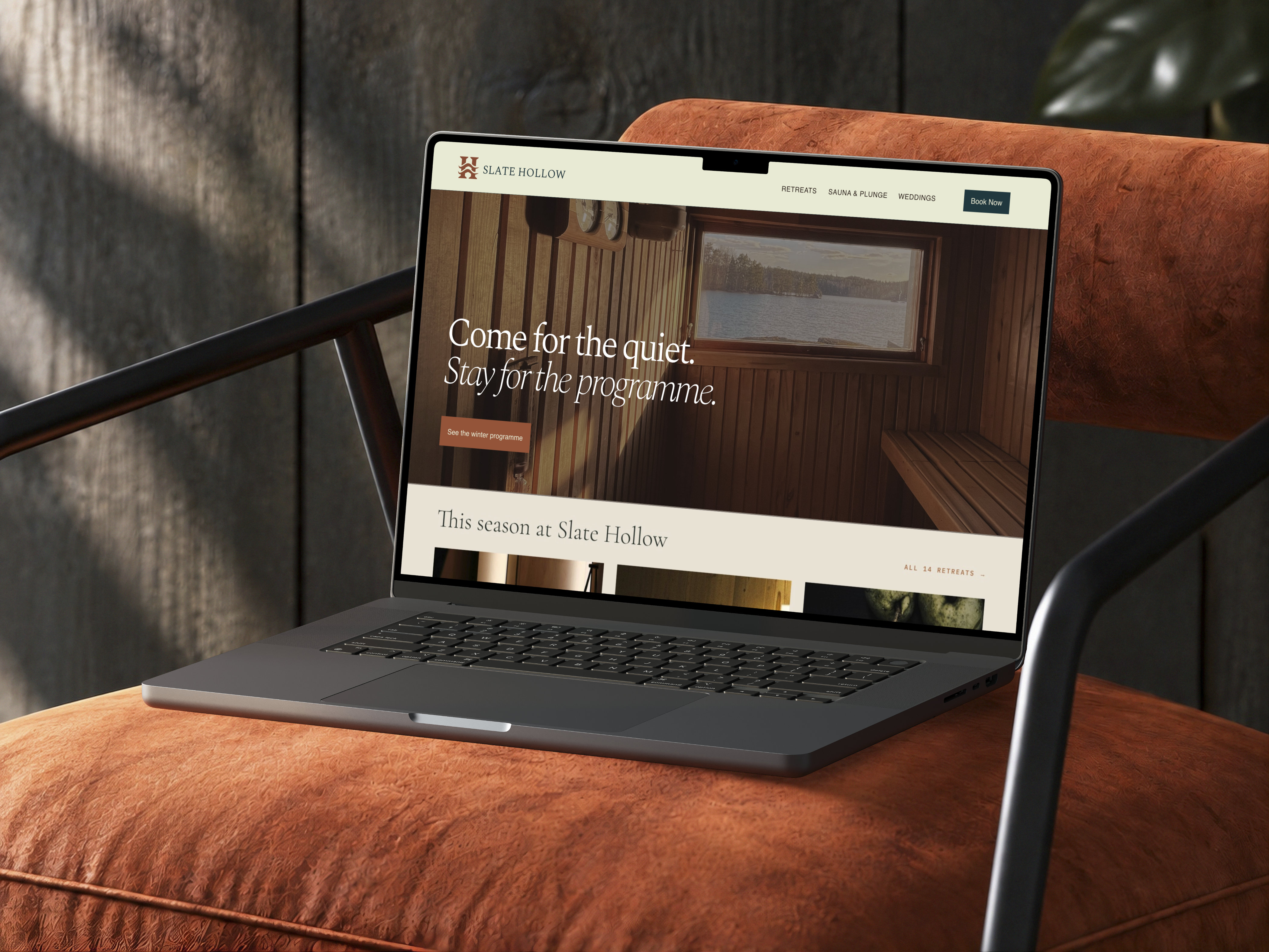 Slate Hollow website homepage open on a laptop resting on a rust-colored lounge chair