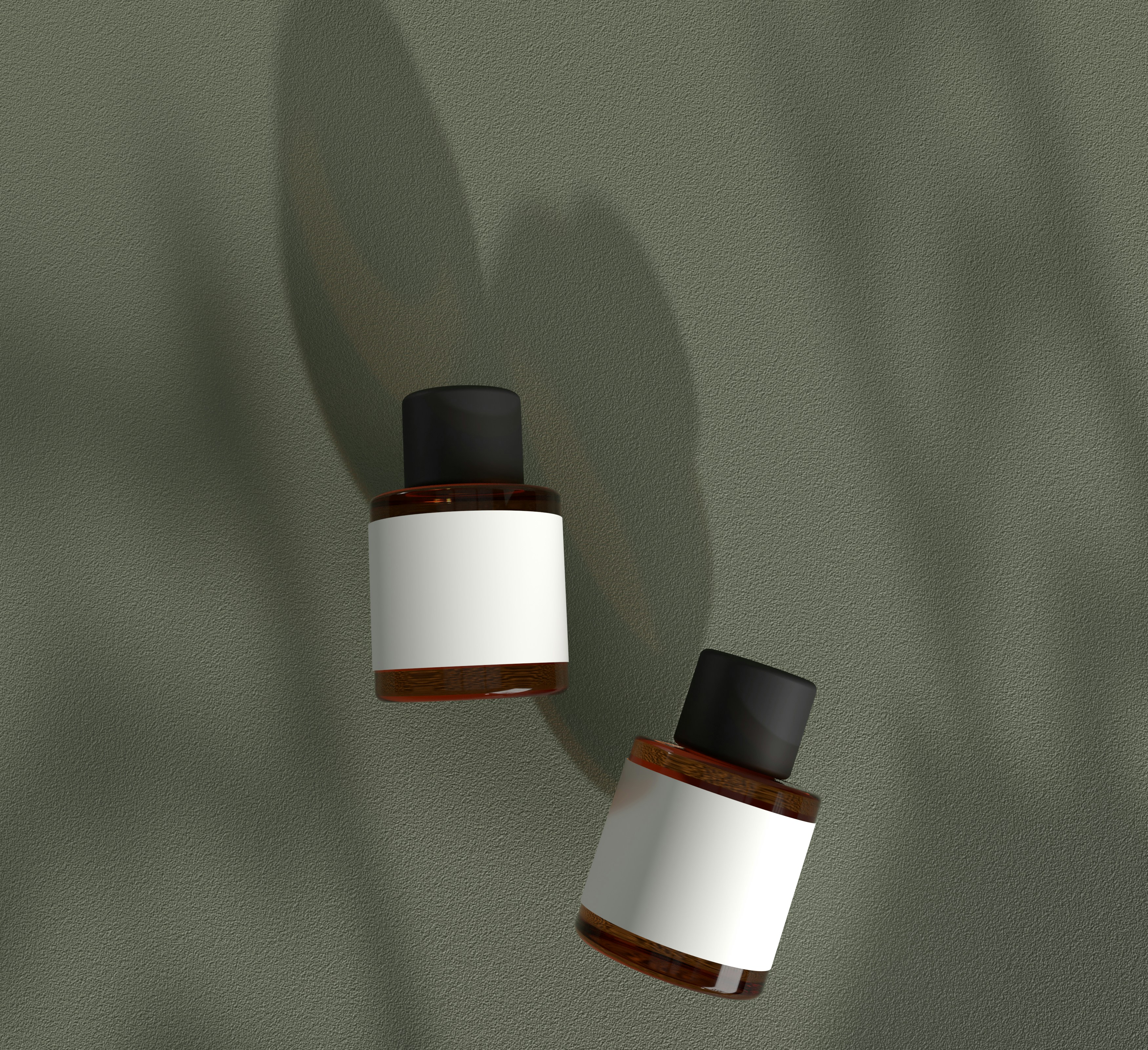 Two amber glass bottles with blank white labels on a sage green surface under leaf shadows