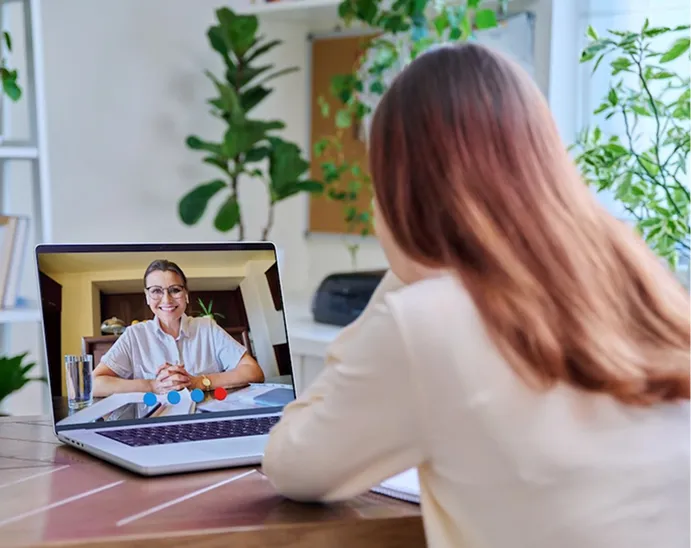 Patient attending a virtual psychiatry appointment on a laptop with a provider on a video call