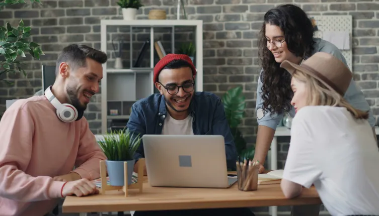 Vier Kolleg:innen arbeiten digital zusammen