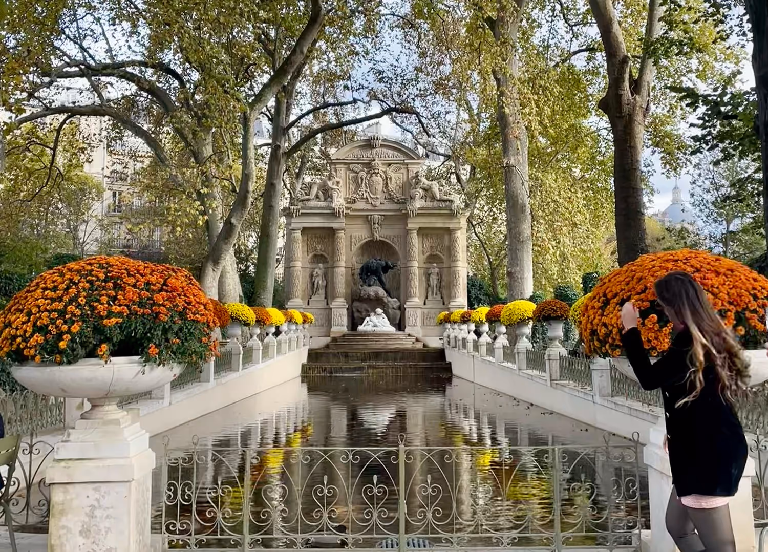 fountain and water ornated with yellow and orange flowers all around