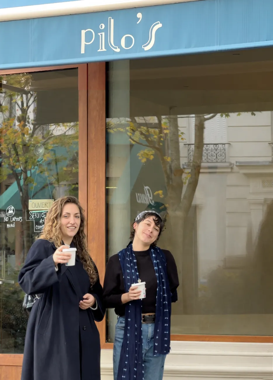 Guide holding a blue sign saying "Dayin" and "Connecting France" in front of a big and colorful glass-bubble modern sculpture.