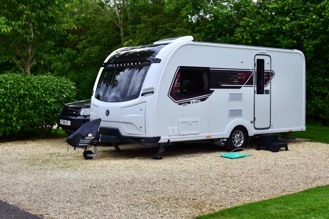 A modern caravan and tow car on a fully serviced pitch at the Caravan and Motorhome Club site on the outskirts of Broadway.