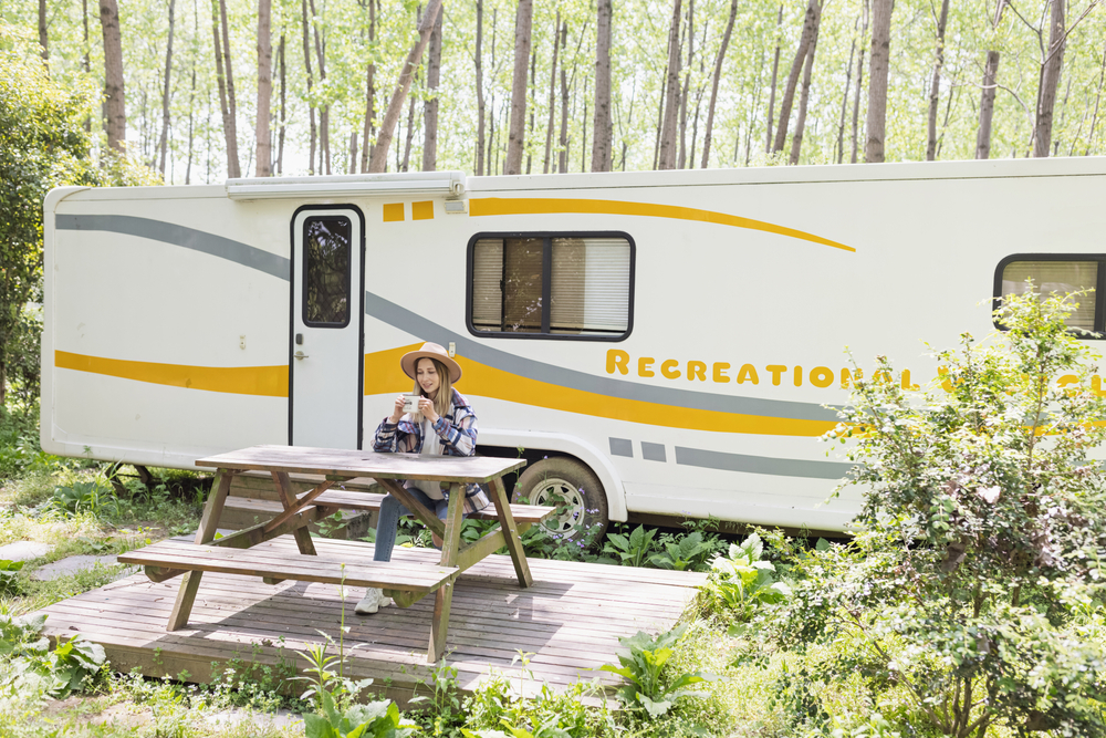 women sat on a bench in front of a caravan