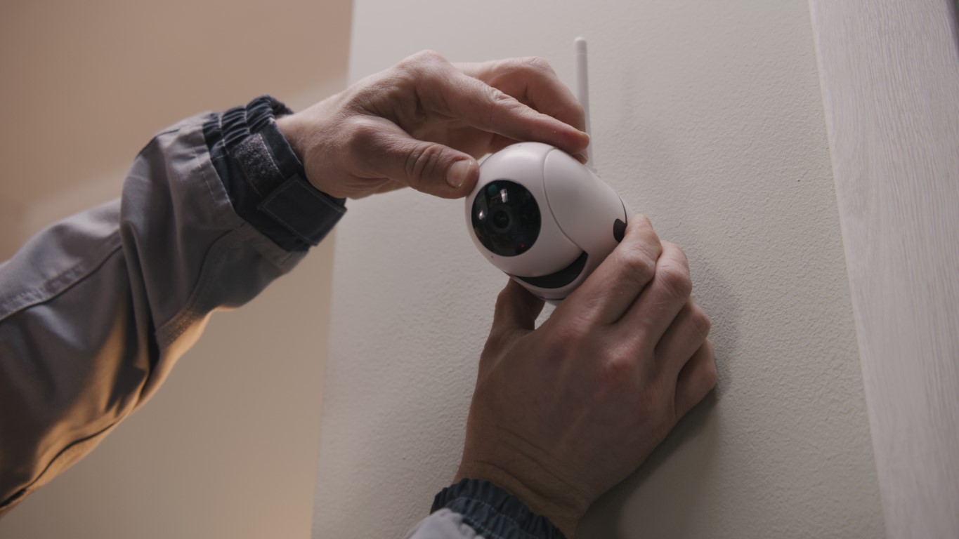 Man installs cameras in house.