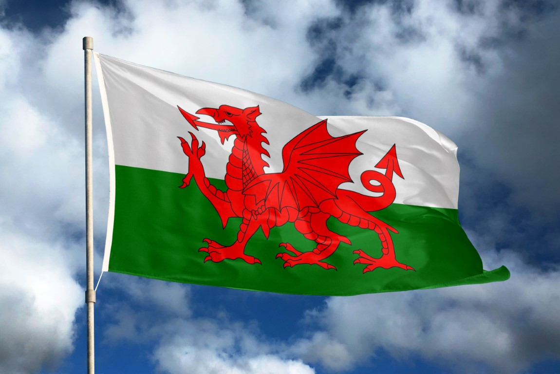 Wales flag on sky and cloud background.