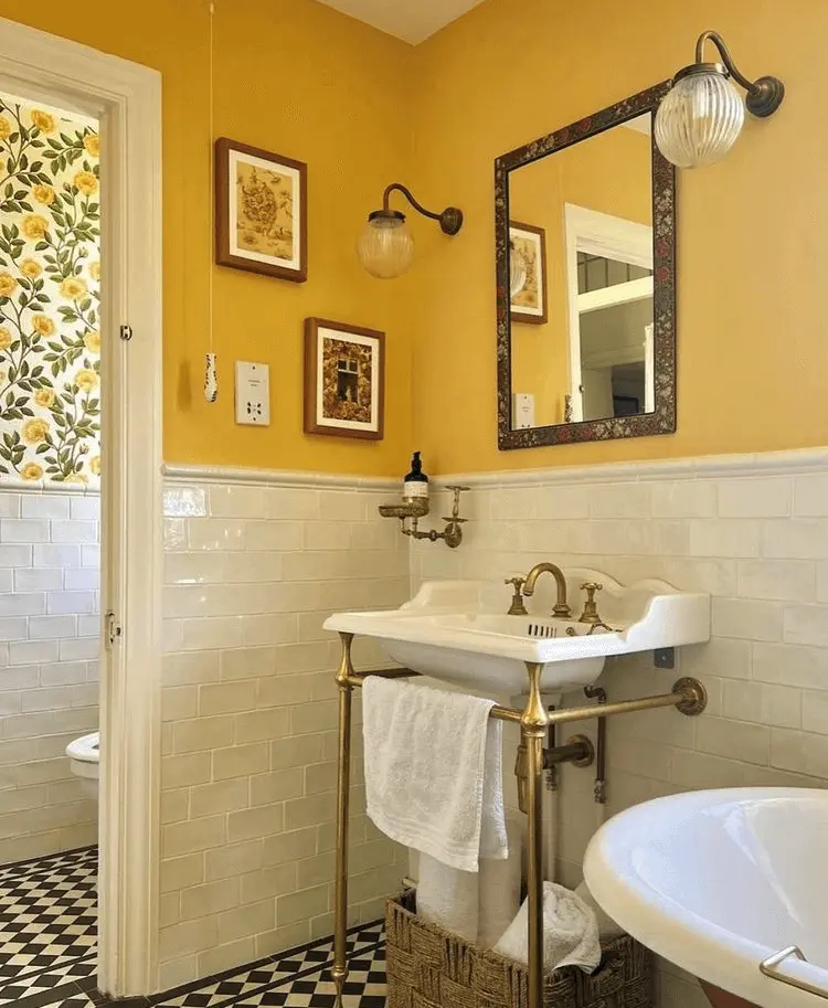 a vintage-style bathroom with yellow walls, half-height subway tile, and black and white floors
