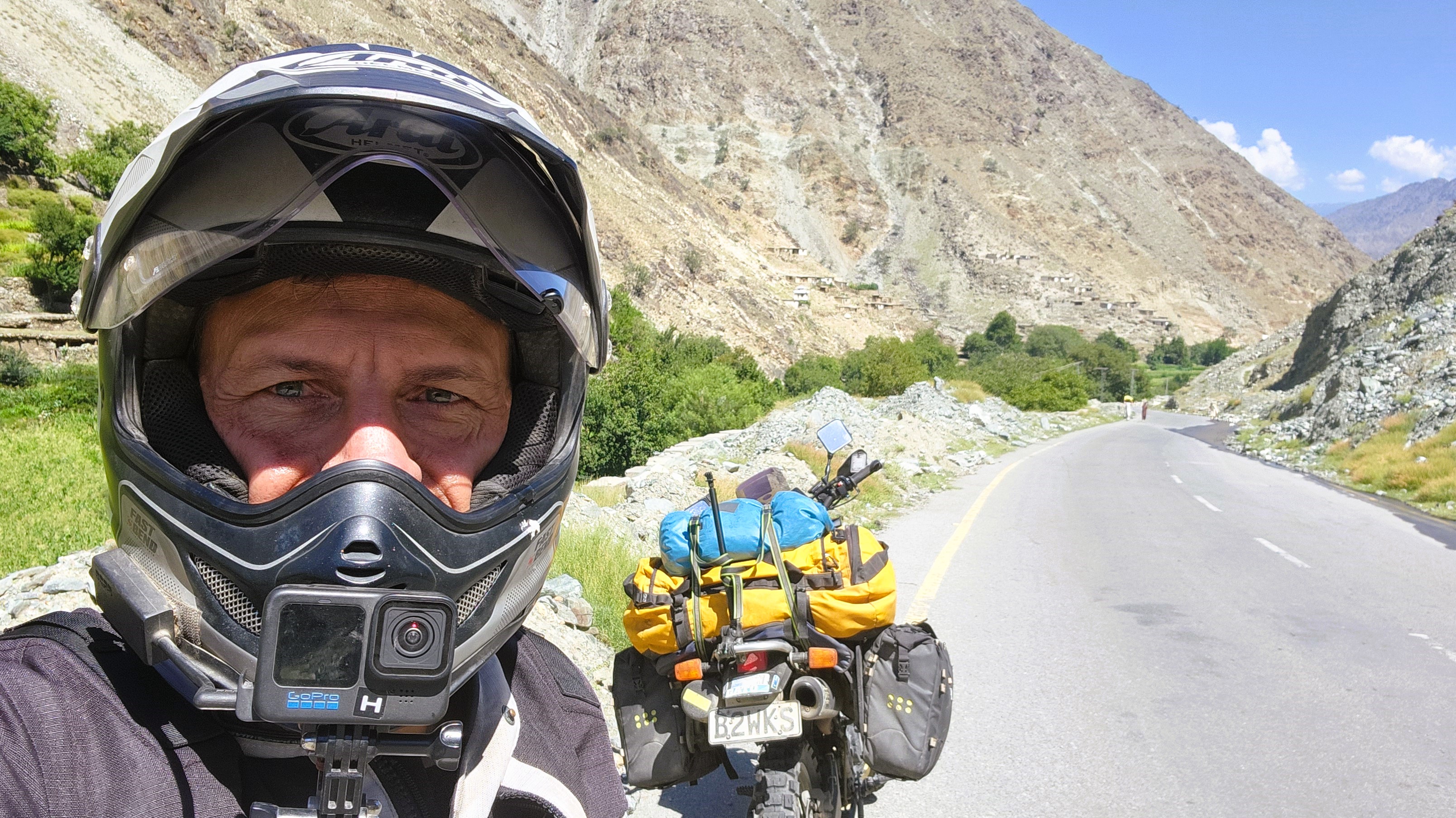 Ray Urlich with his motorbike on the road with the mountains in the background