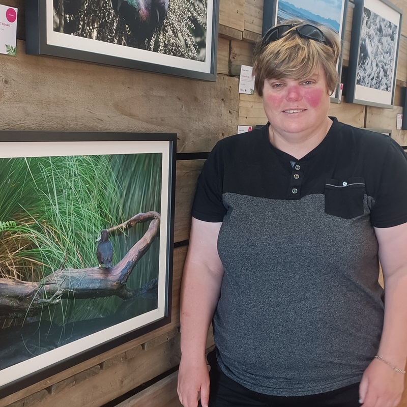 Danielle Zam standing next to her winning photograph 'Whio'