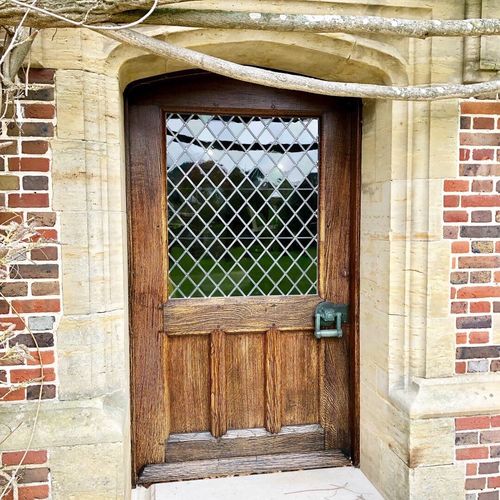 Close up of a wooden window frame on the side of a red brick house.