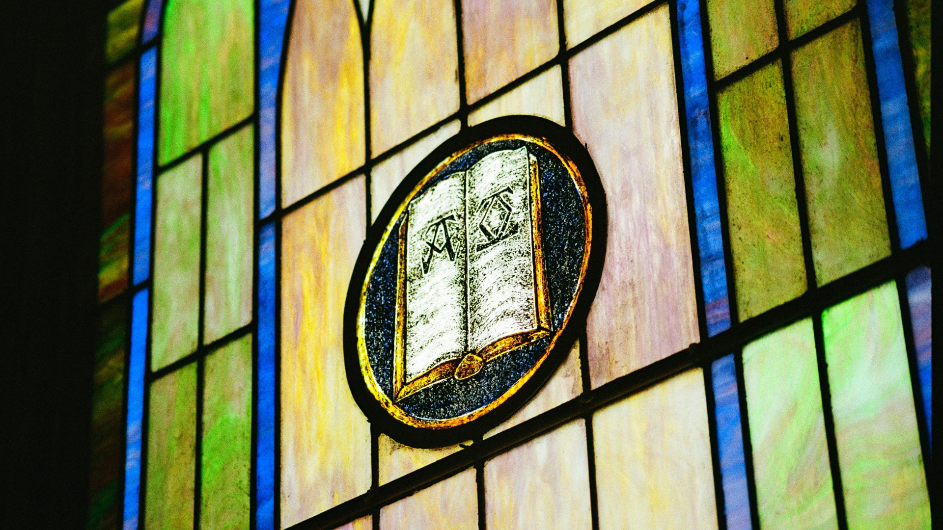 Medieval stained-glass window with imagery of a book. 