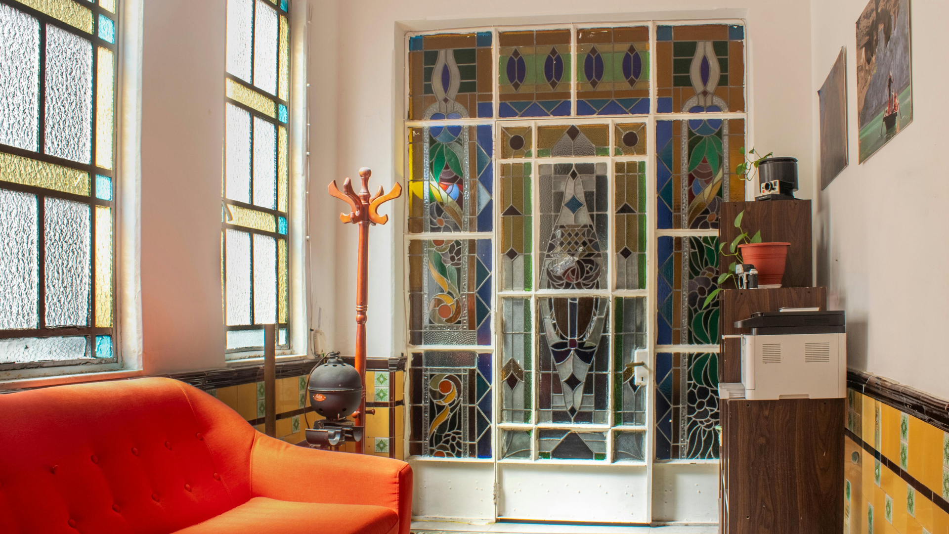Modern hallway with an intricate stained-glass door dividing the room. 