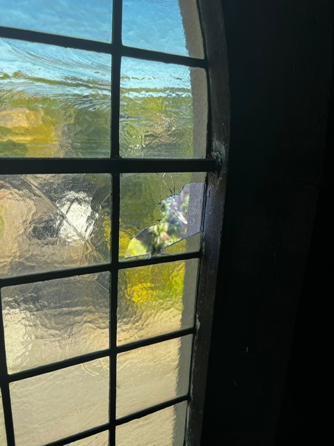 Close up of a wooden window frame on the side of a red brick house.