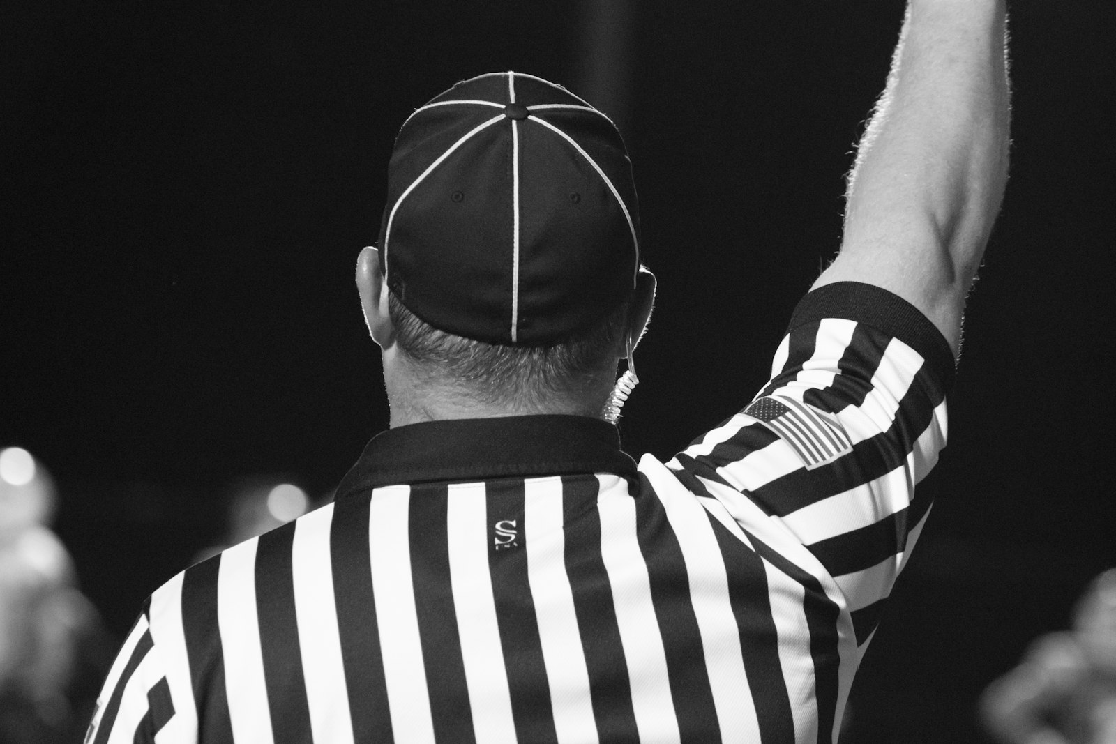 Arbitre vu de dos, bras leve, maillot raye