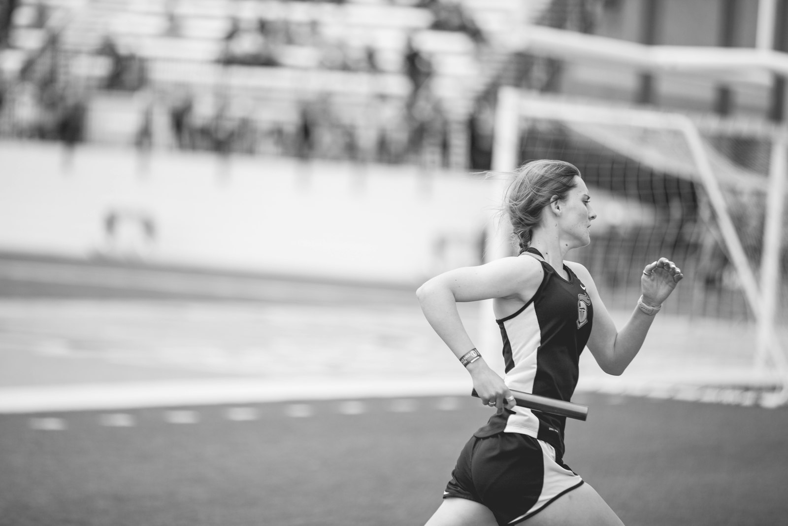 Athlete courant avec un temoin de relais a la main