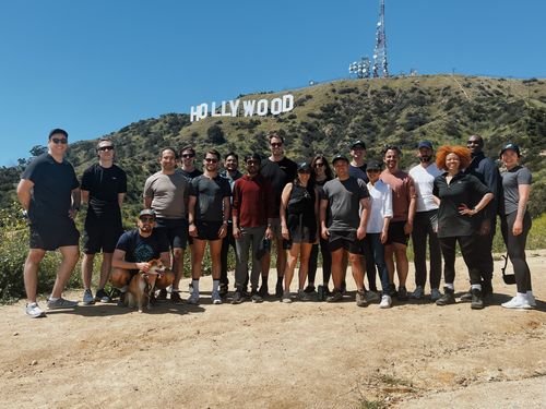 a green tree frog emerging through a green leaf.