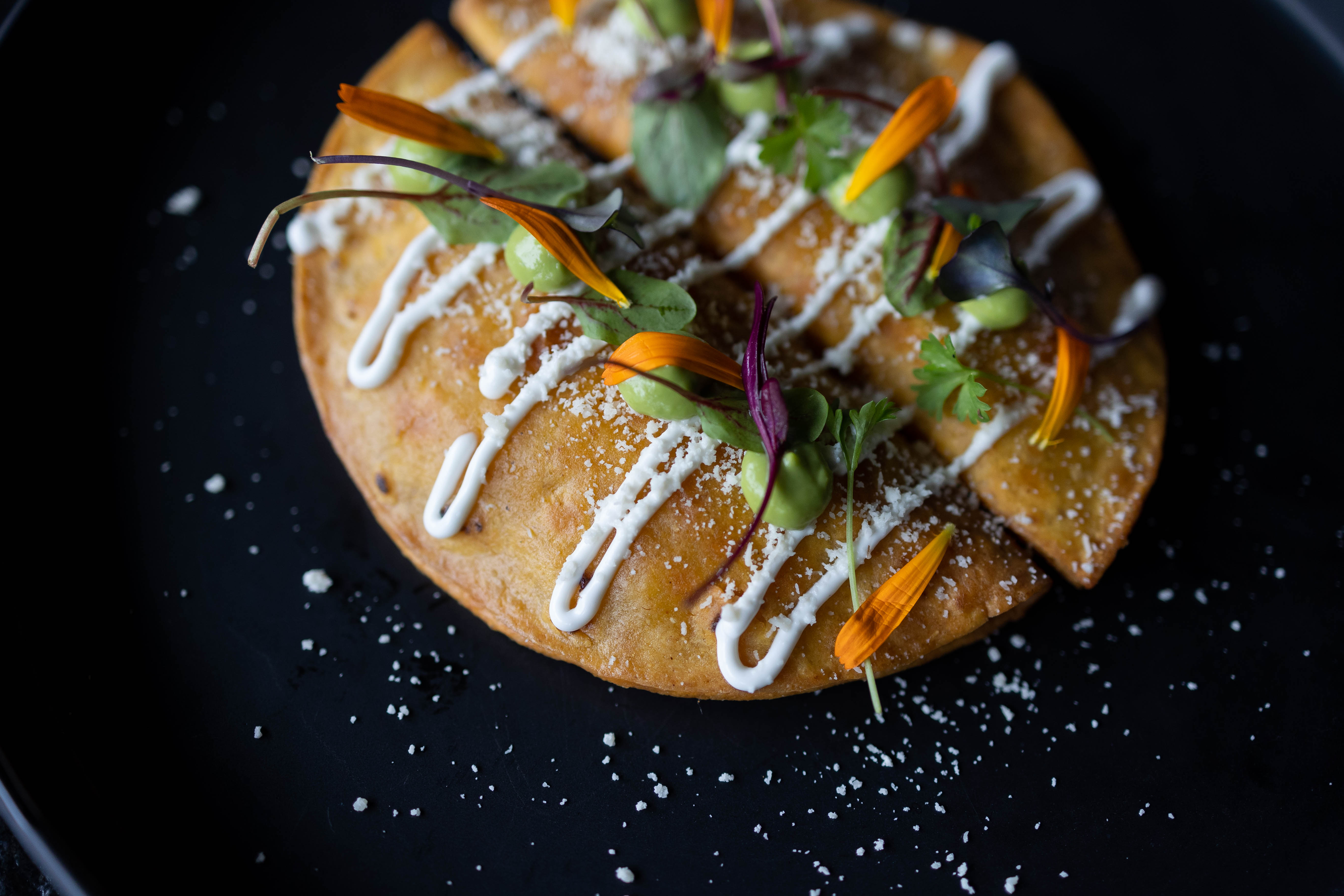Our Tacos de Papa appetizer. Two potato and mushroom filled tacos topped with cotija cheese and crema