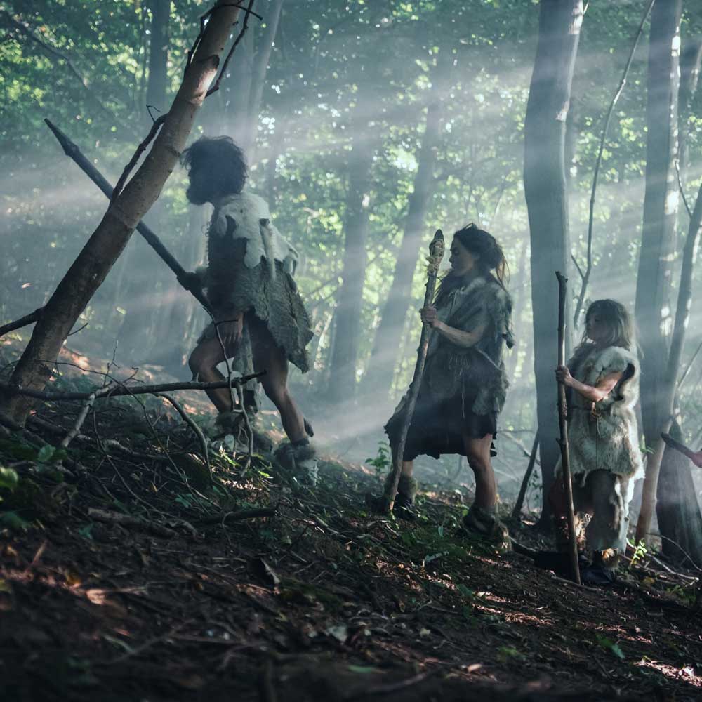 Palaeolithic men walking bare foot in the forest