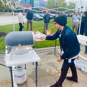 Parking lot pizza party for my coworkers, featuring me making a pizza.