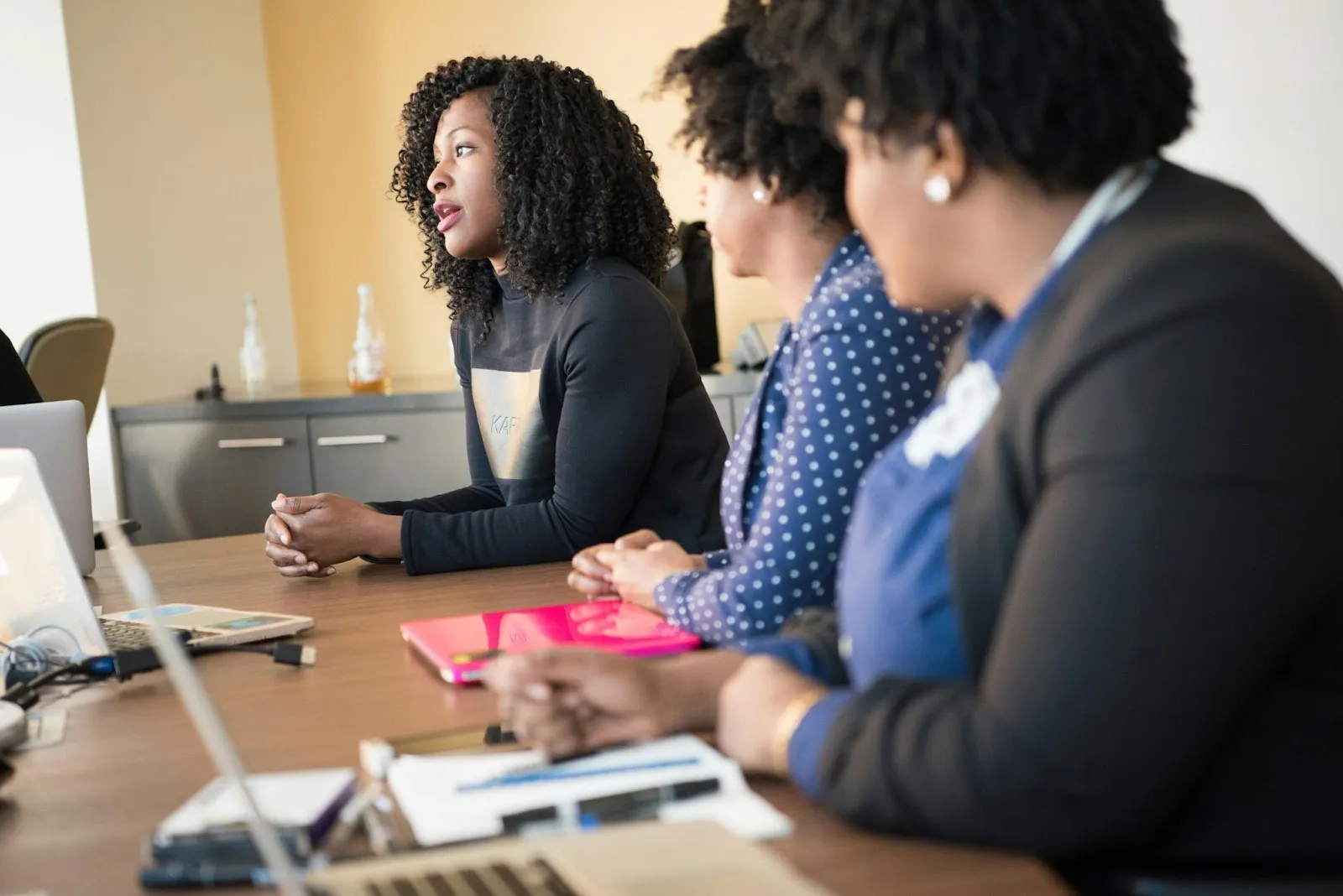A group of women administrators sit at a table and discuss their evaluation system.