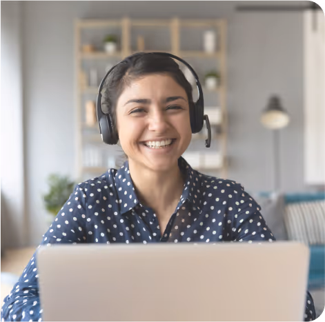 A smiling man sitting next to a laptop