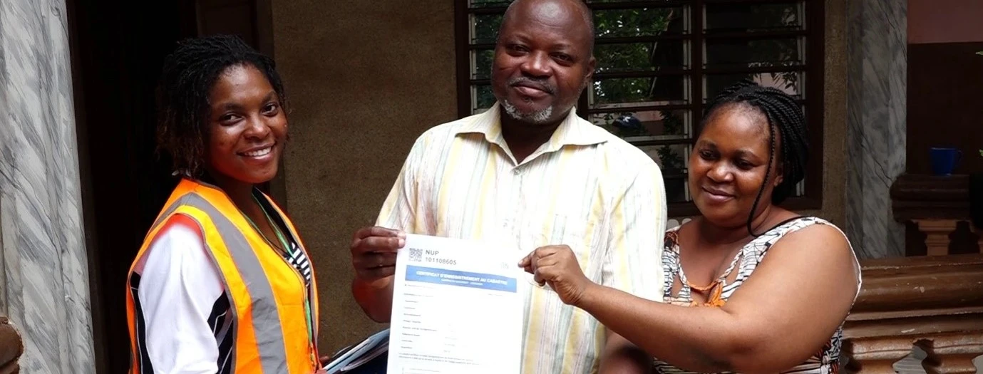 Een ambtenaar overhandigt een kadastraal certificaat aan een inwoner van Sèmè-Podji, Benin.
