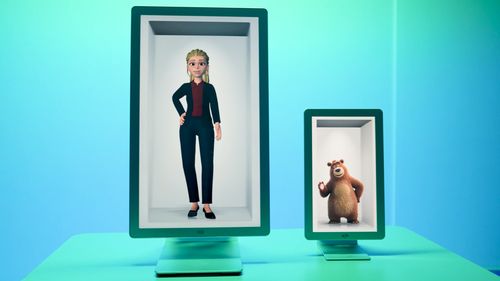 Two Hololuminescent™ Displays (HLD)s on a turquoise surface display a 3D animated woman in business attire and a waving animated bear in separate rectangular frames.