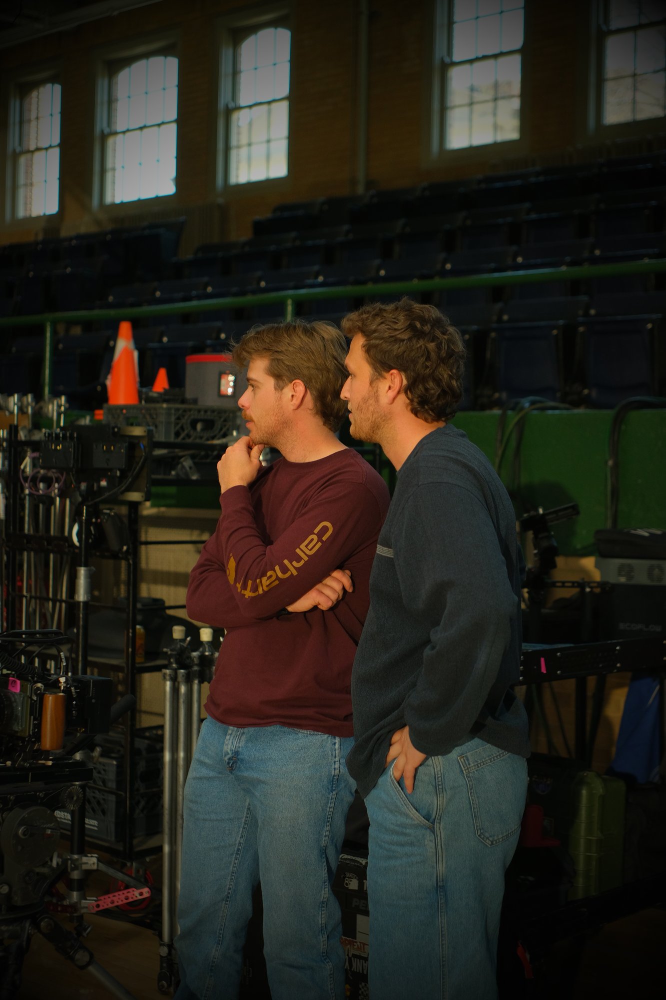 Two crew members watching a take beside the camera cart