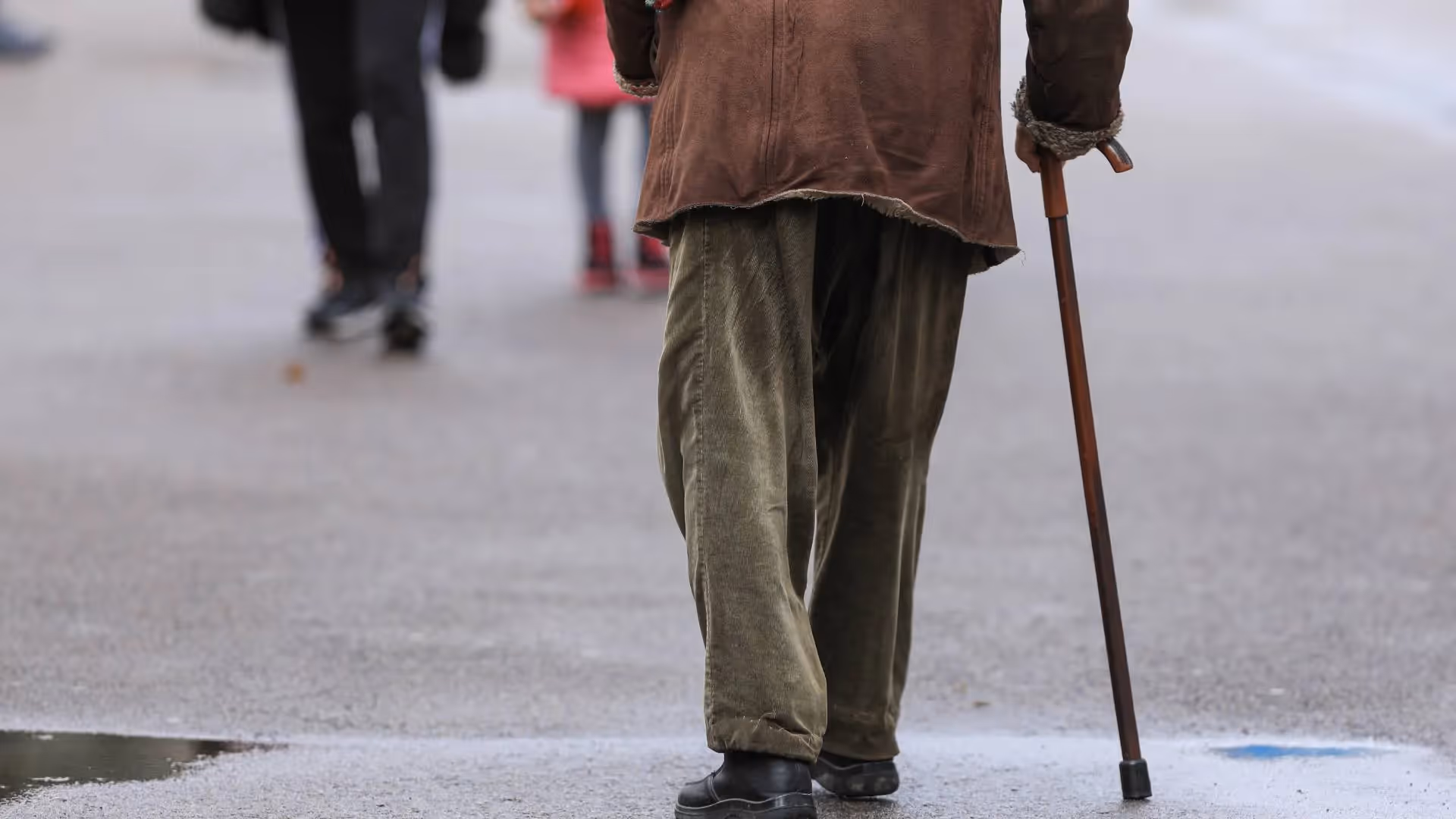 An elderly person crossing a street