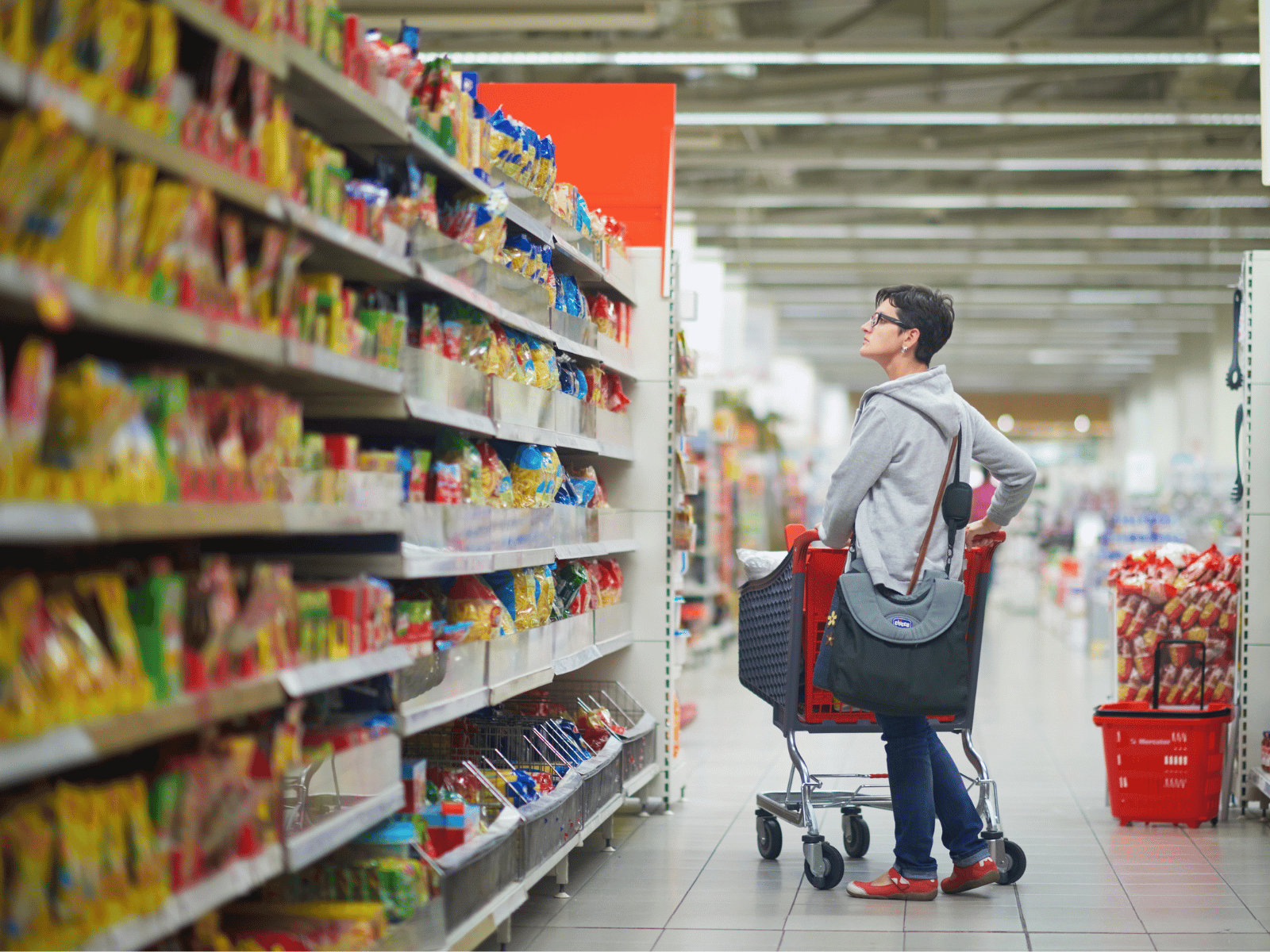Customer browsing a supermarket shelf. 