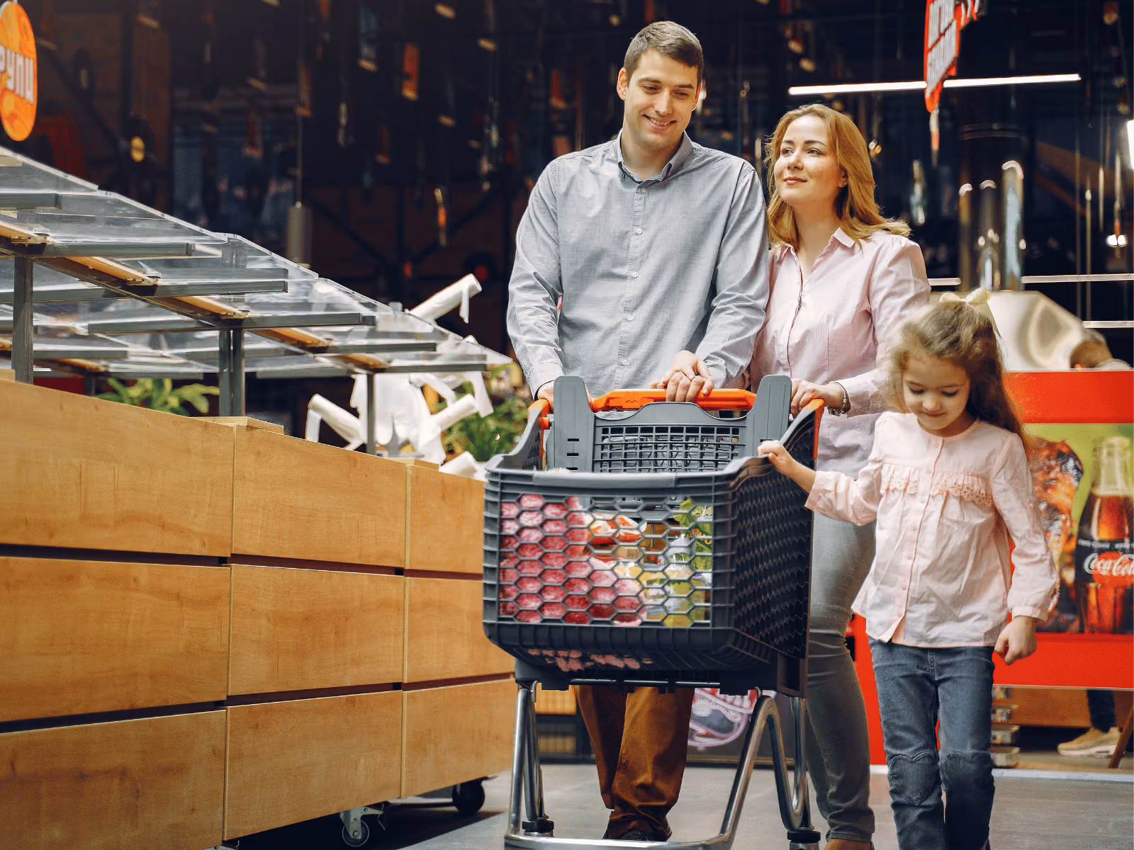 Family walking with cart through a supermarket