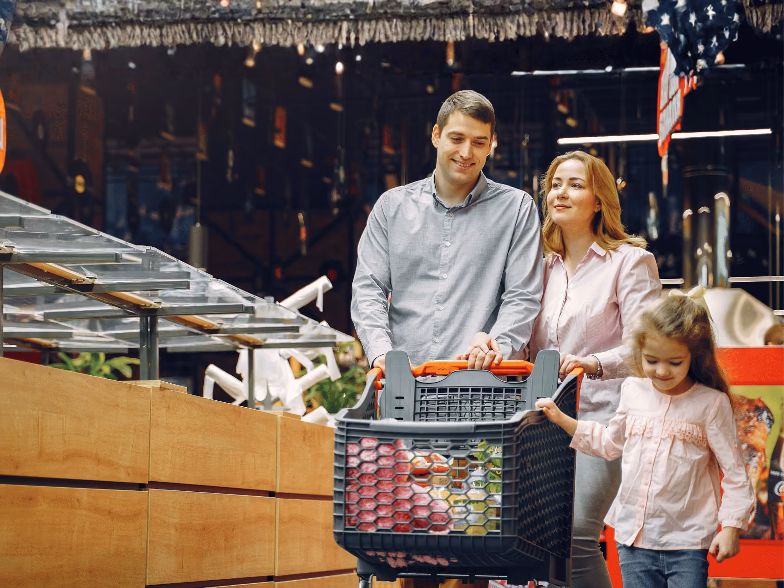 Family walking with cart through a supermarket